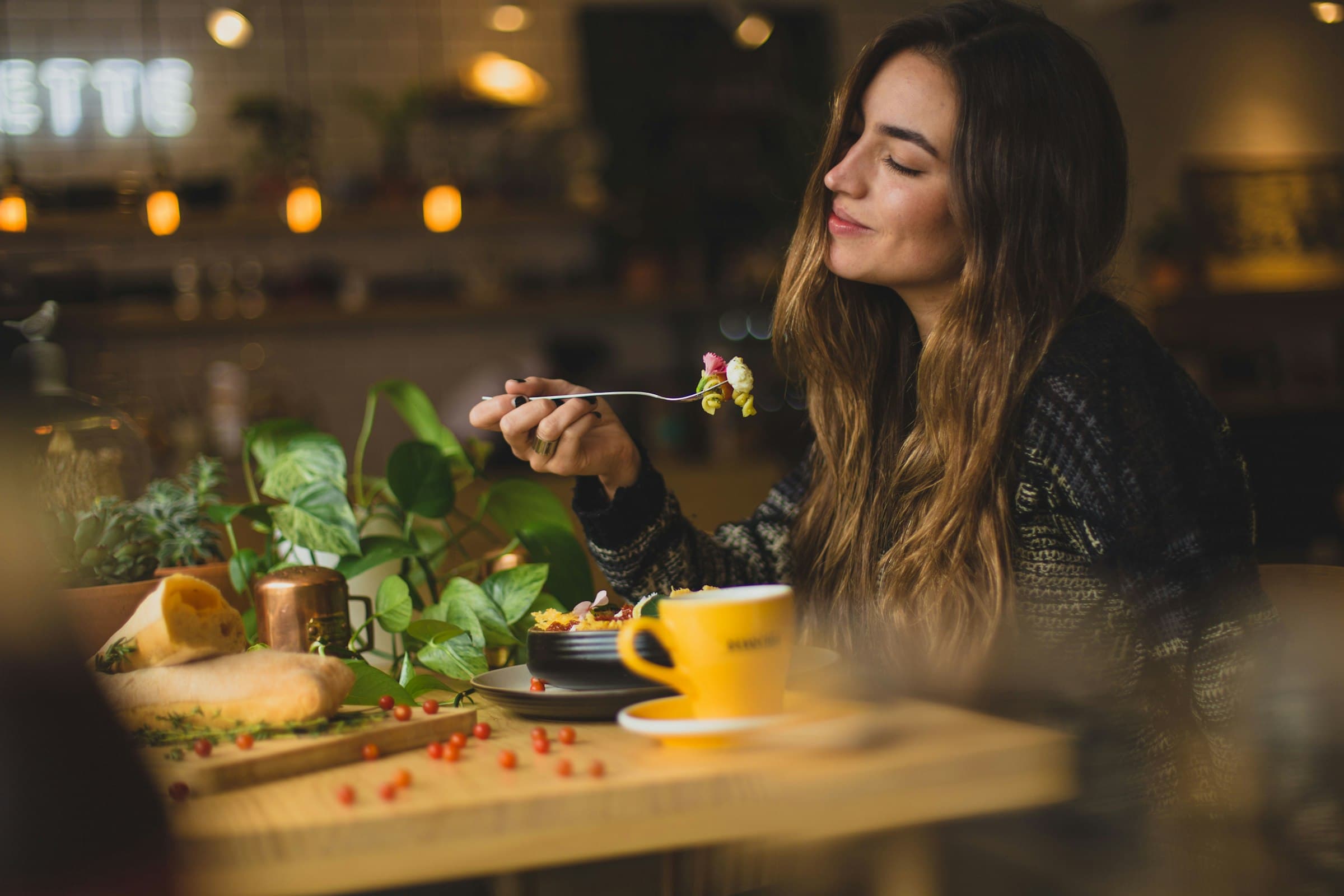 Una persona comiendo una ensalada fresca con atención, enfocándose en cada bocado