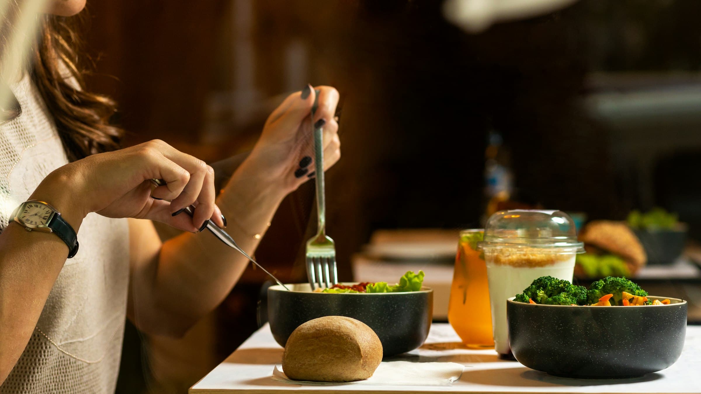 Una persona comiendo una ensalada fresca con atención plena bajo la luz natural, en un ambiente sereno.