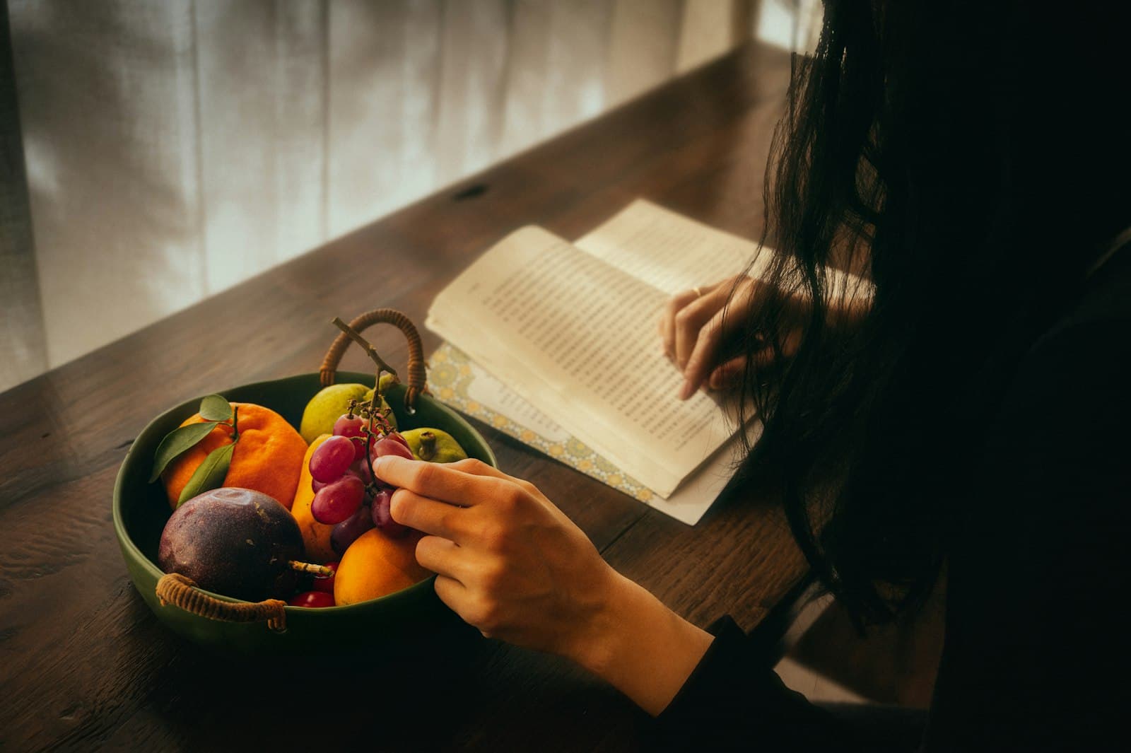 Manos sosteniendo un tazón de frutas y verduras frescas y coloridas