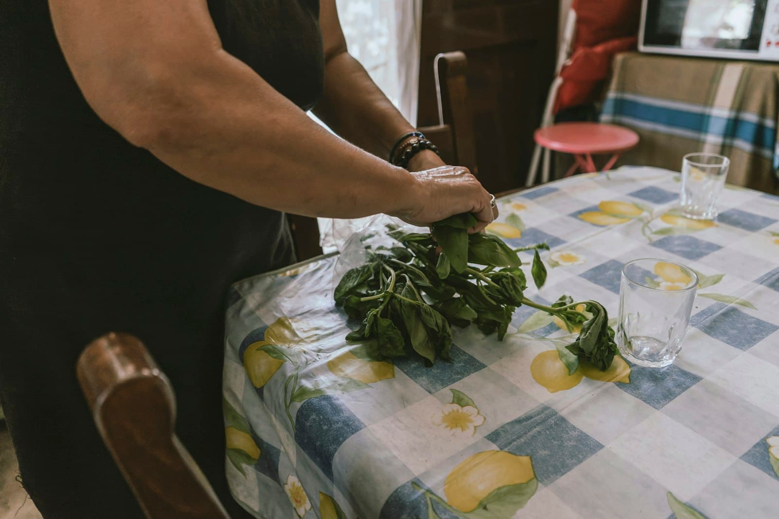 Primer plano de una persona oliendo hierbas frescas antes de cocinar, ambiente sereno