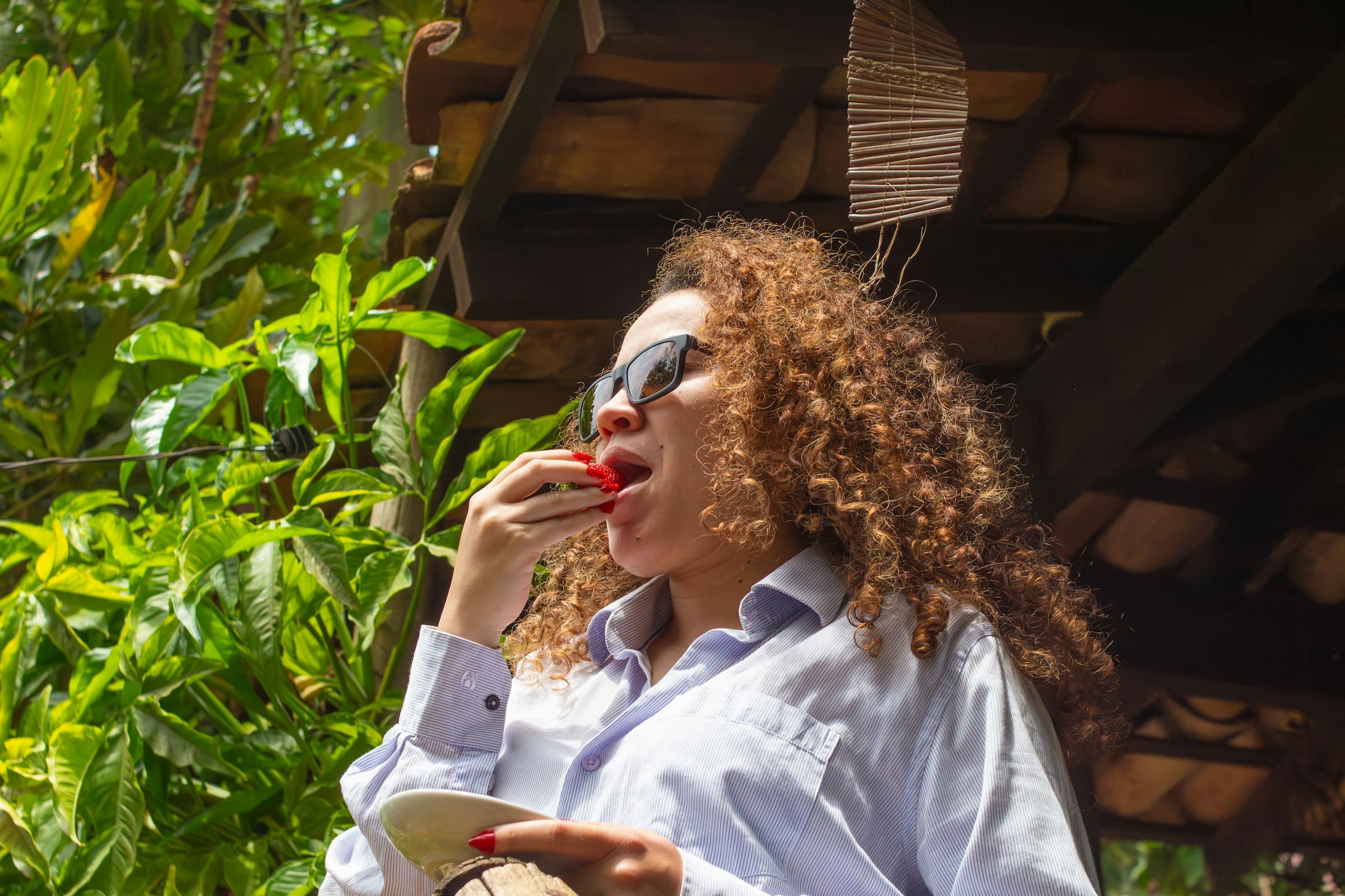 Una persona sonriendo mientras saborea una comida saludable al aire libre, con luz natural y un ambiente sereno.