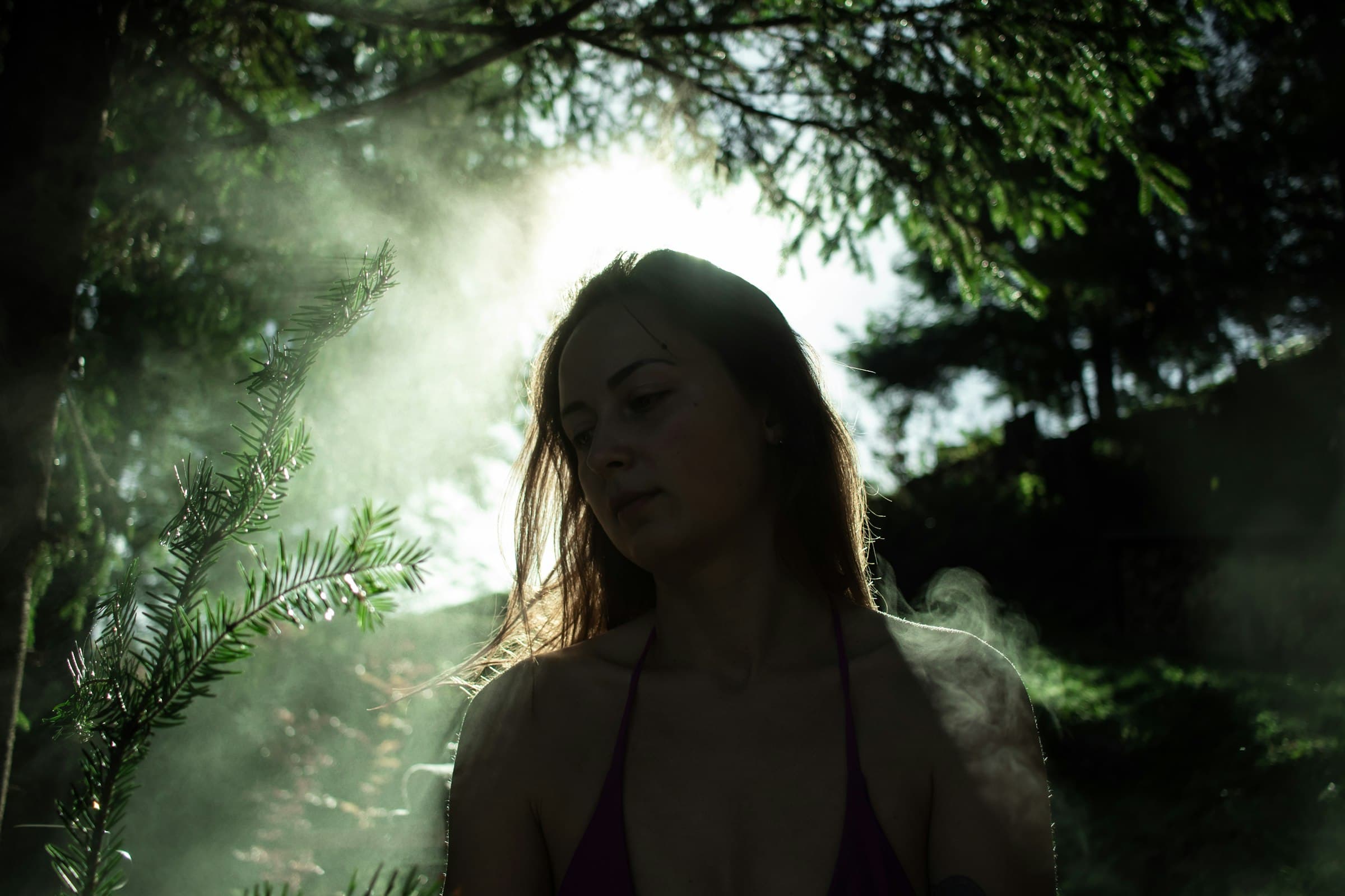 Una persona sentada tranquilamente en un entorno natural brumoso y sereno, meditando.