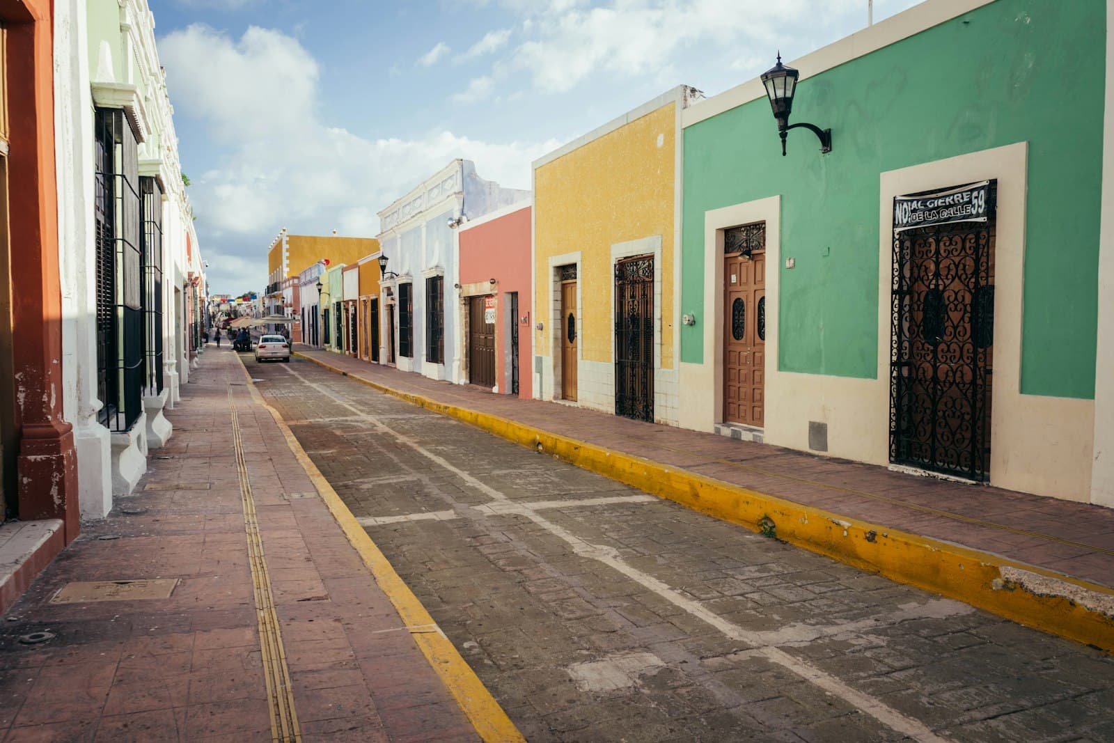 Una calle colorida y tranquila en el centro histórico de Mérida con arquitectura colonial.