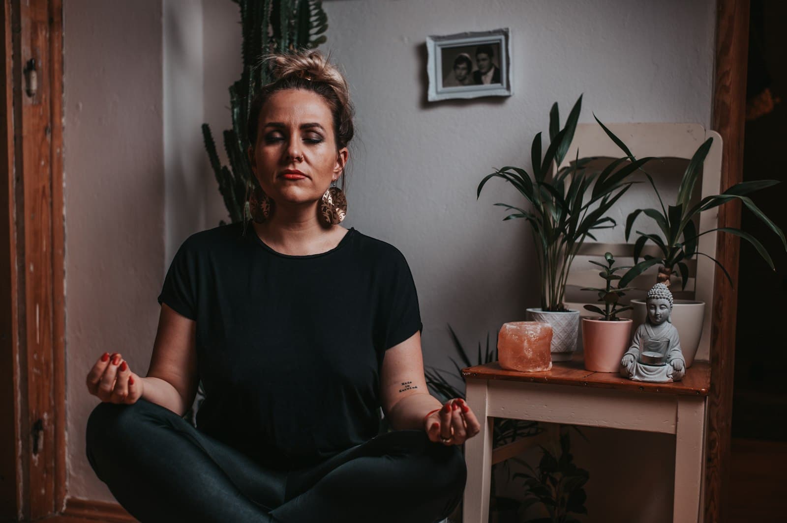 Persona meditando en una habitación serena iluminada por el sol con decoración sencilla