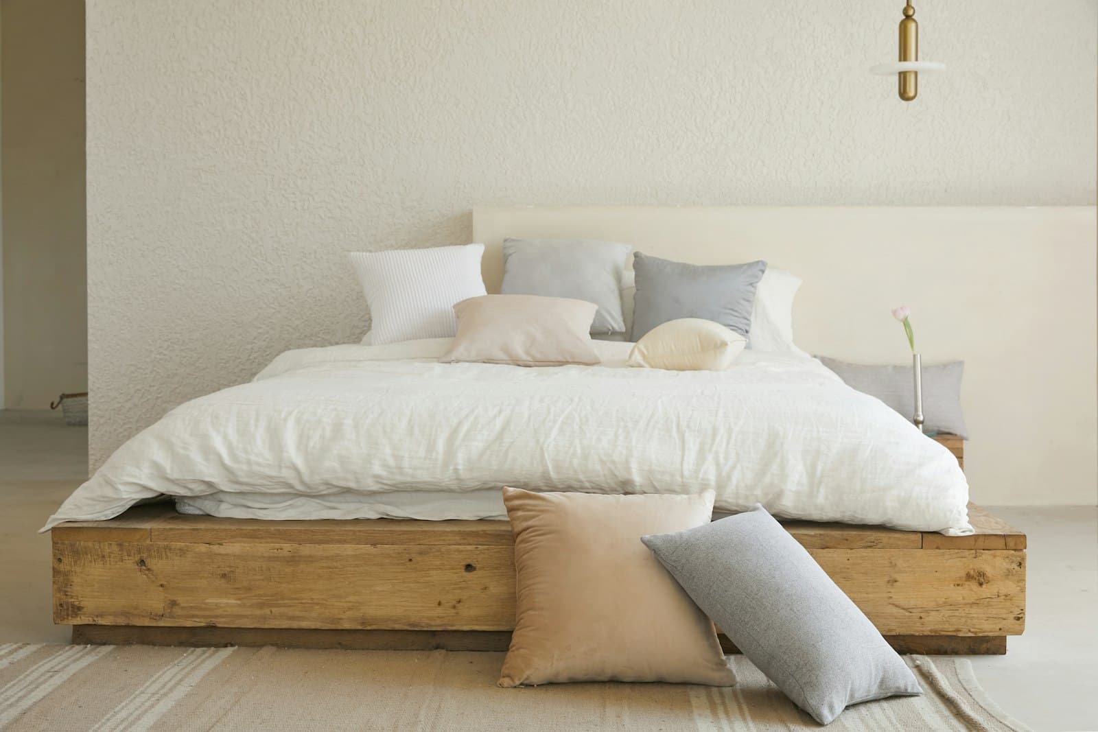 Dormitorio minimalista con texturas suaves y materiales naturales, con luz tenue