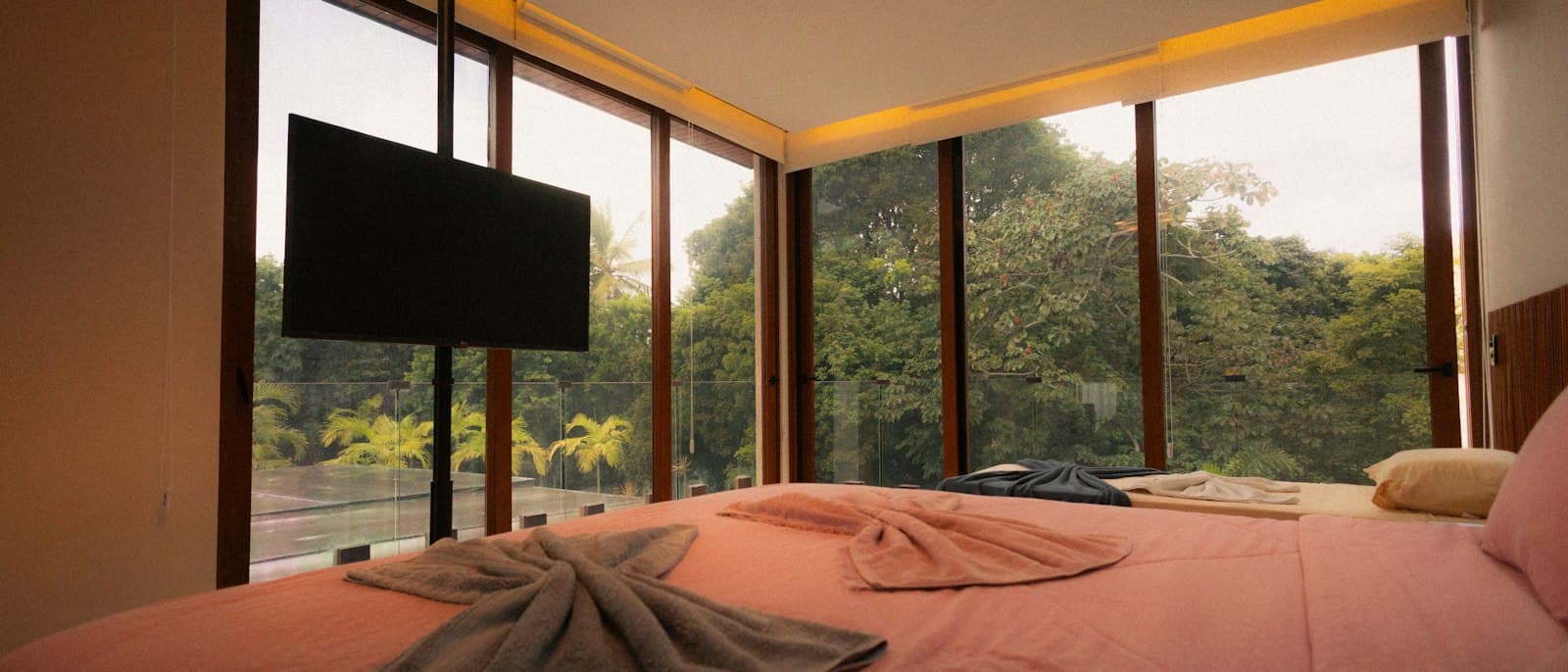 Dormitorio minimalista con tonos cálidos, luz tenue y plantas, creando una atmósfera relajante