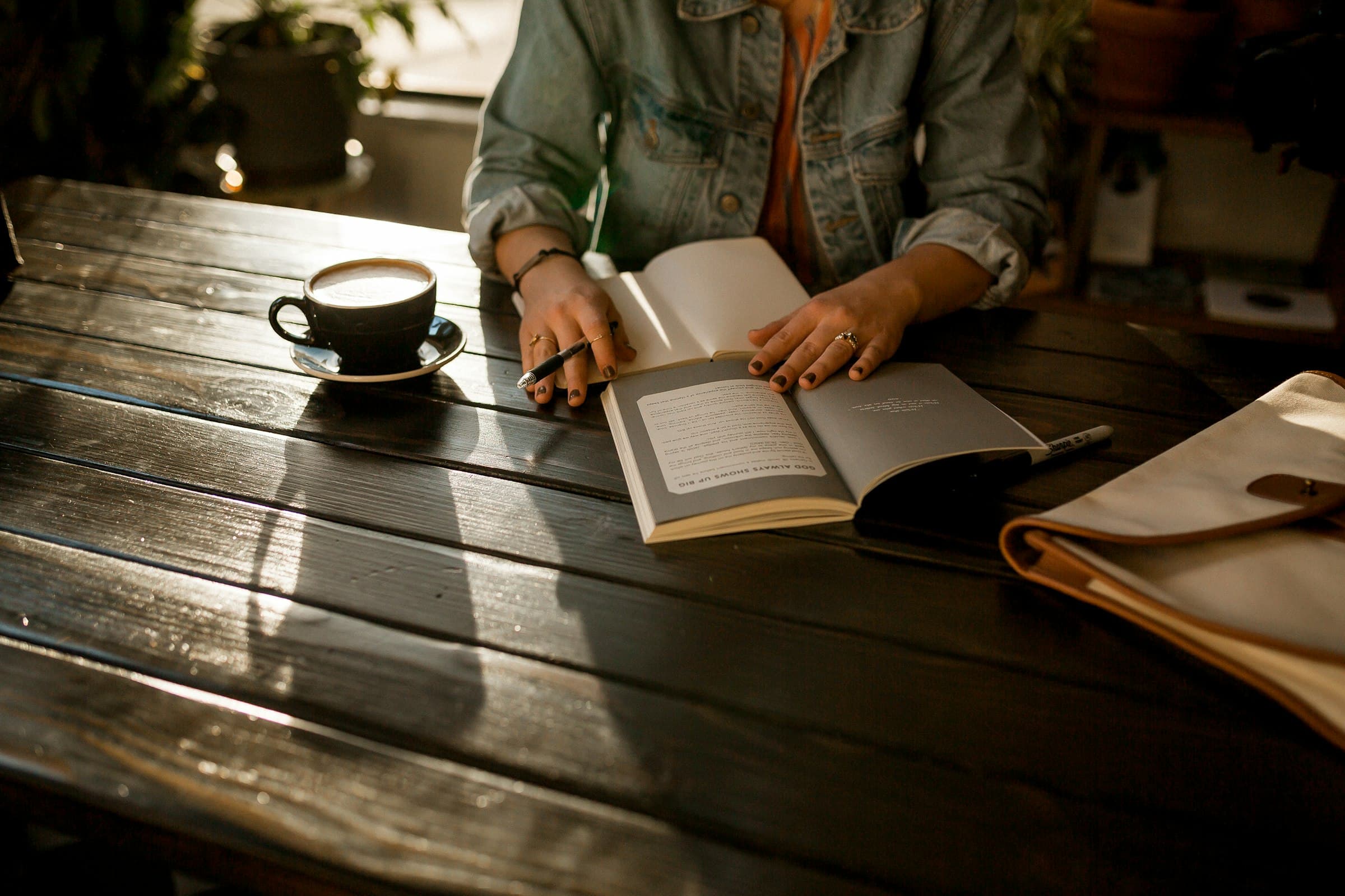 Persona escribiendo en un diario, con luz suave de la mañana iluminando la escena