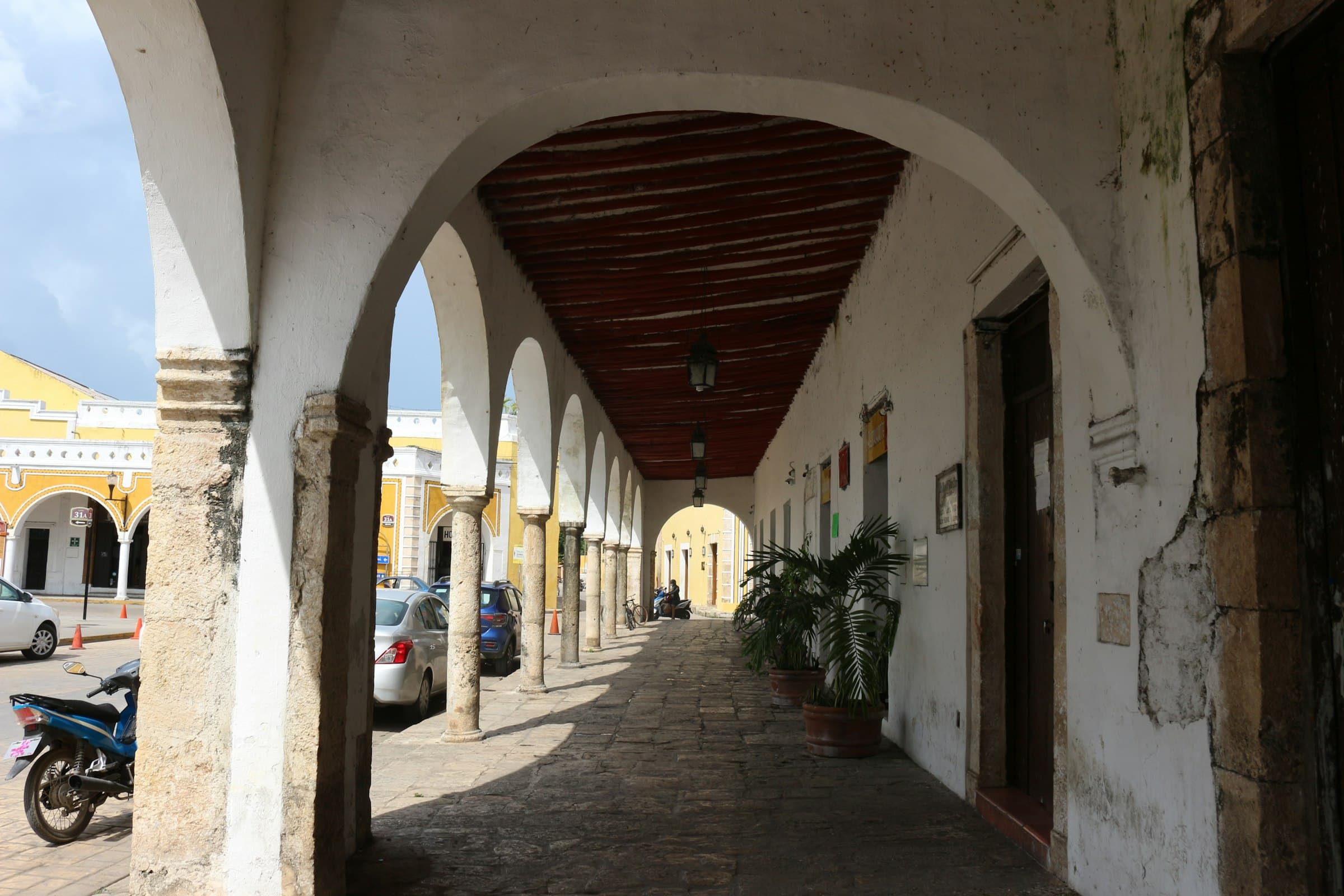 Calle tranquila con arquitectura colonial en Mérida, Yucatán, bajo un cielo sereno.