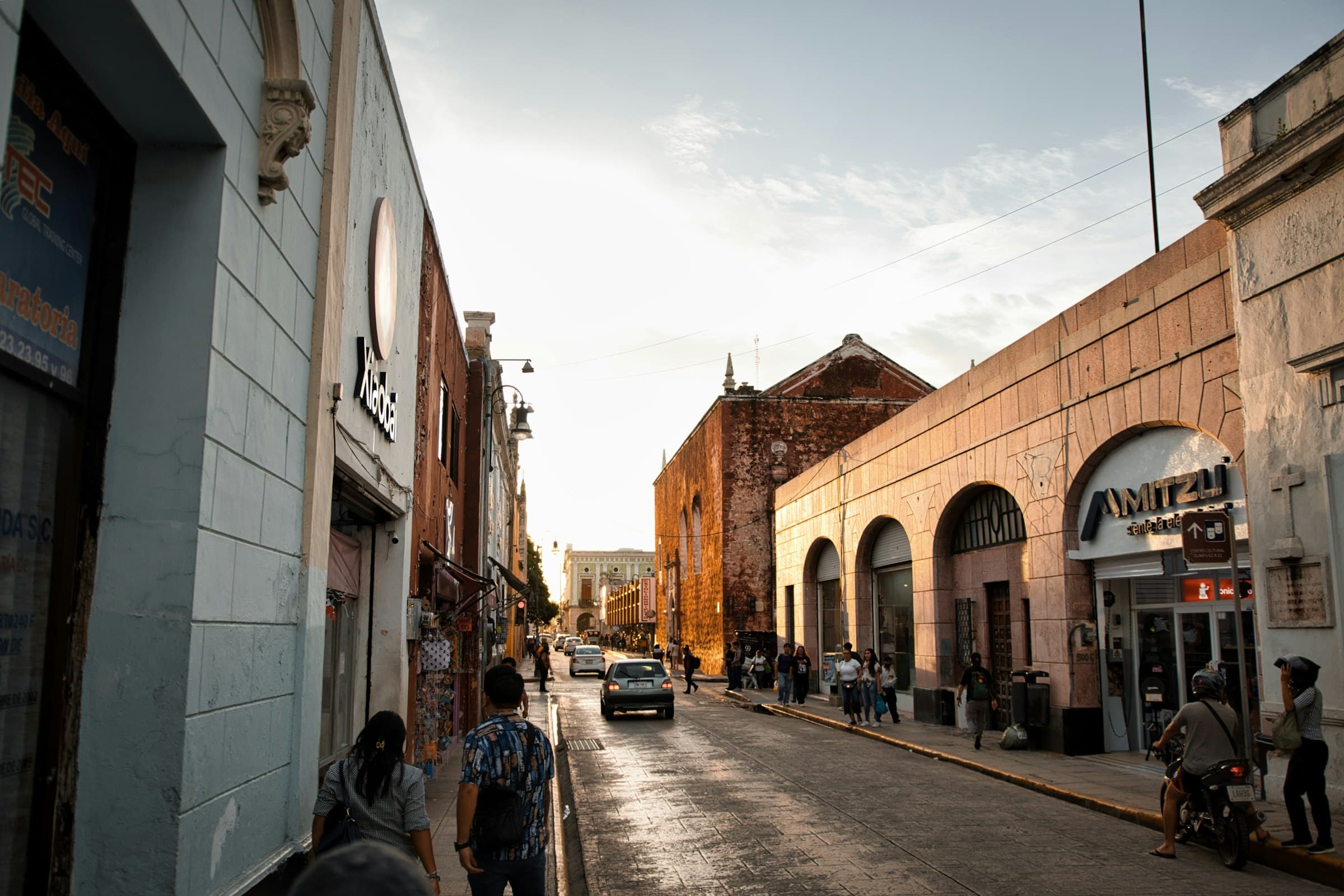 Calle colonial tranquila en Mérida con fachadas coloridas y poca gente