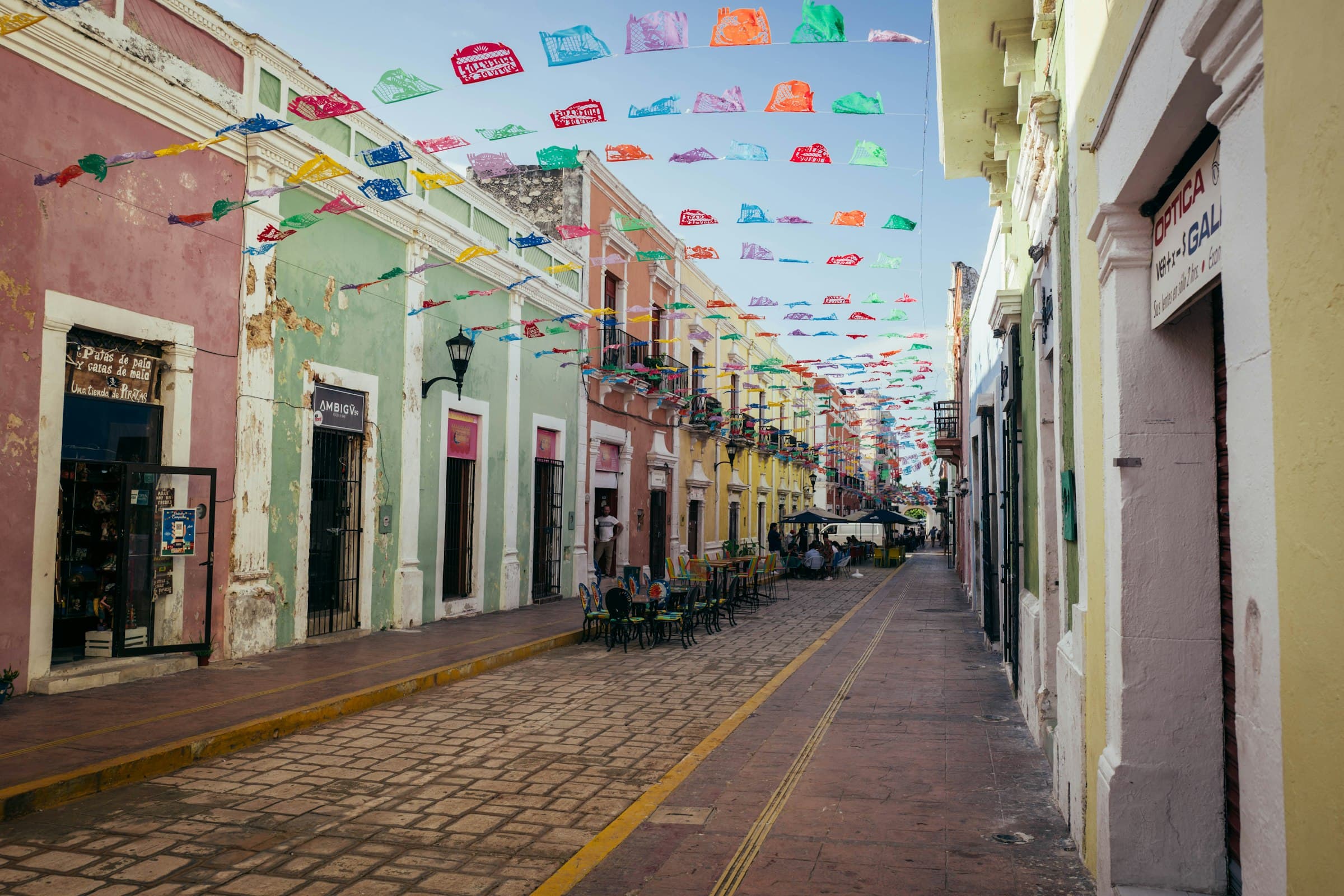 Calle colonial de Mérida con edificios coloridos y vegetación exuberante