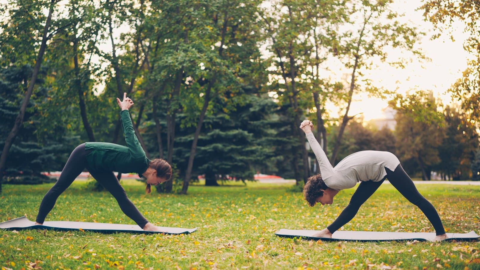 Una persona estirándose o haciendo yoga al aire libre, con la naturaleza alrededor y la luz temprana del día.