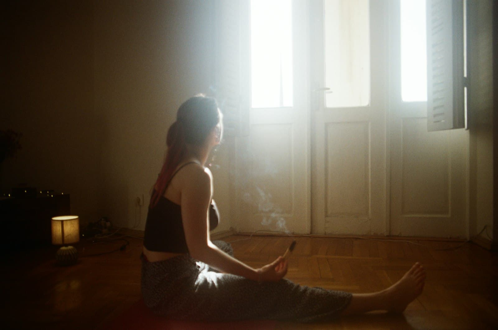 Persona meditando pacíficamente junto a una ventana con la luz de la mañana