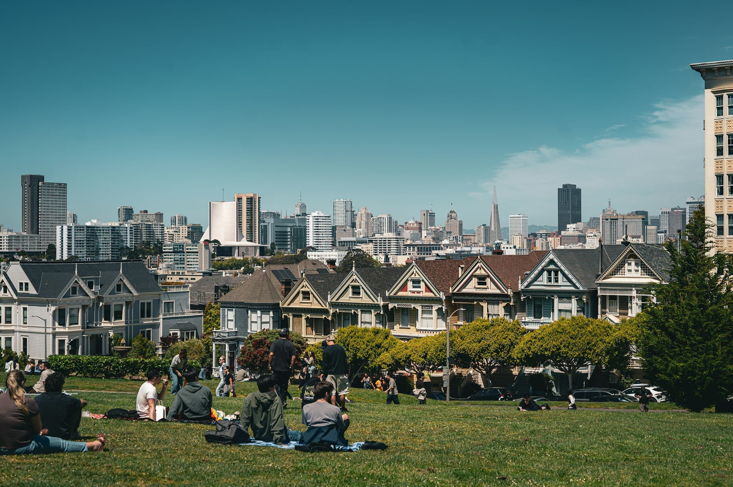 Una persona meditando tranquilamente en un parque urbano, con edificios de la ciudad de fondo