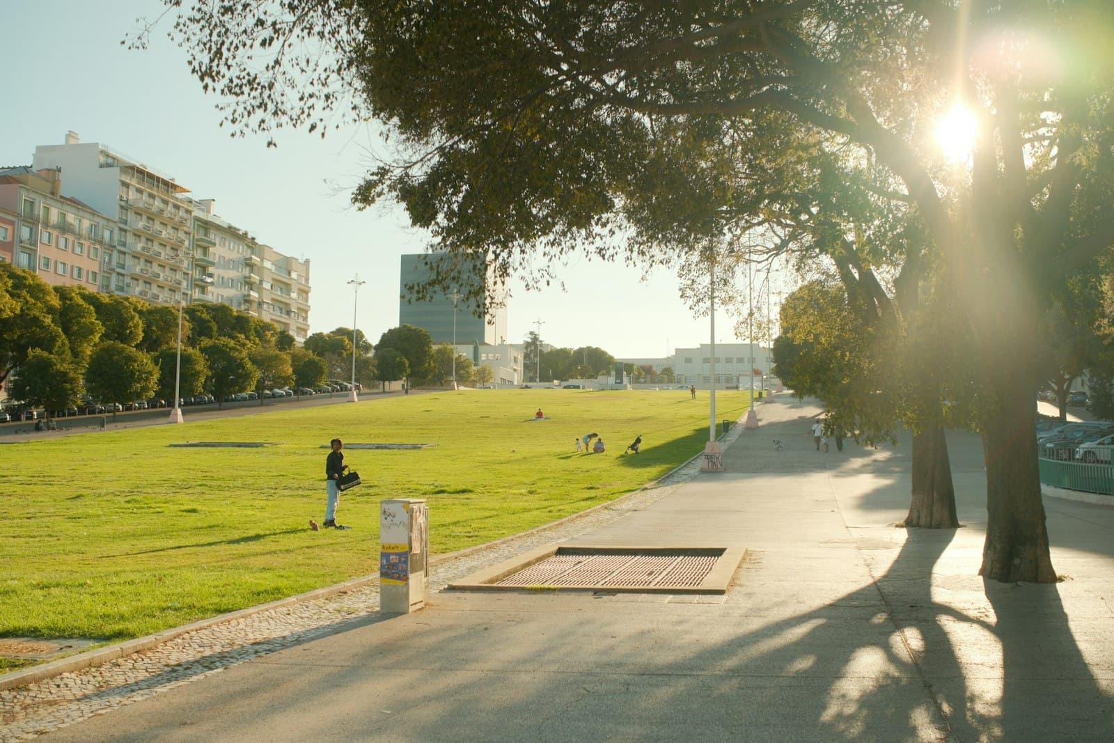 Primer plano de los pies de una persona caminando descalza sobre la hierba en un parque de la ciudad, conectando con la naturaleza urbana.