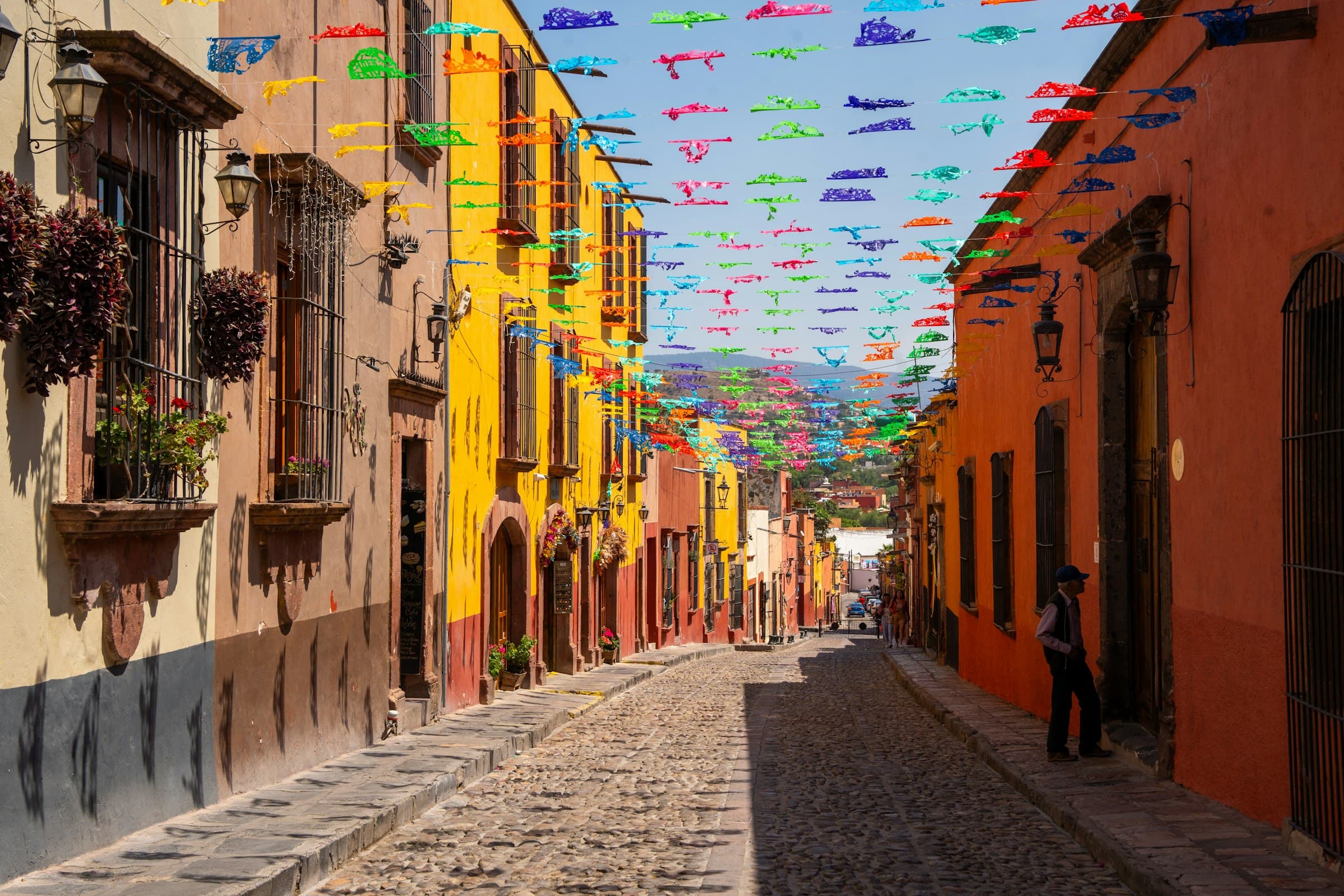 Calle empedrada de San Miguel de Allende al amanecer con arquitectura colonial y luz cálida