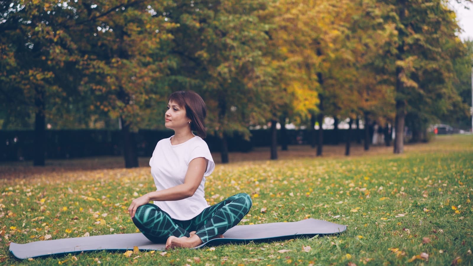 Grupo de personas practicando yoga al aire libre en un entorno tranquilo, conectando con la naturaleza