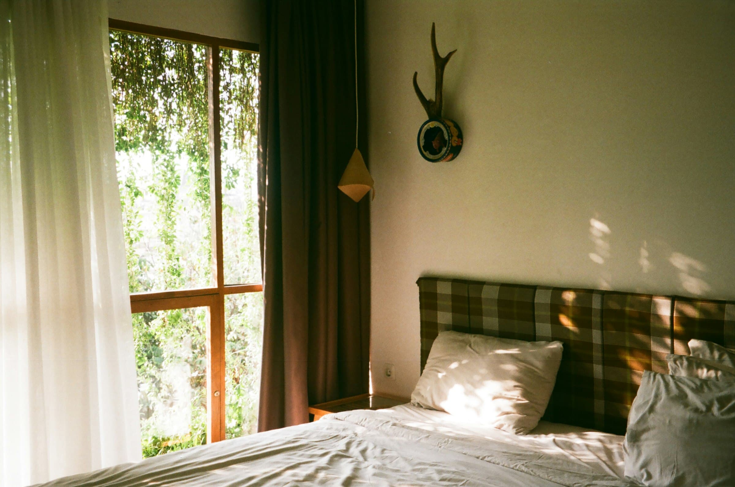 Dormitorio sereno con luz suave entrando por la ventana, invitando al descanso