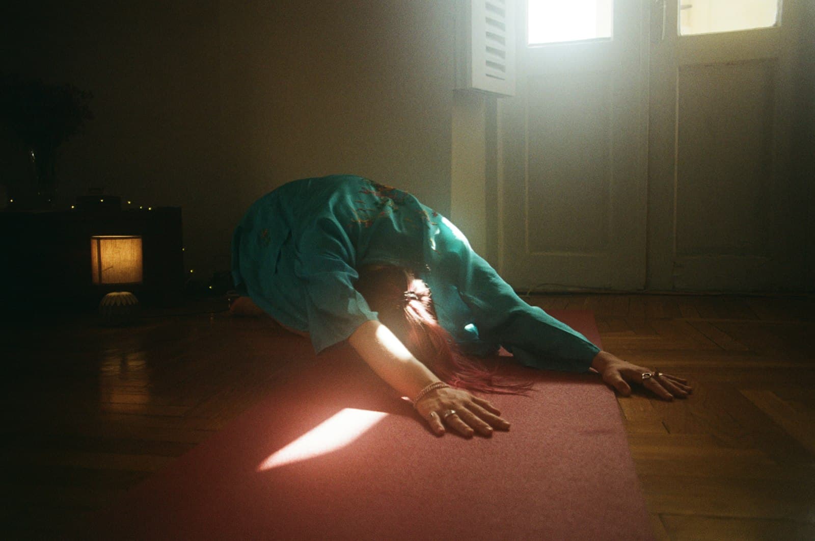 Una persona estirándose suavemente al amanecer, con movimientos que honran el cuerpo.