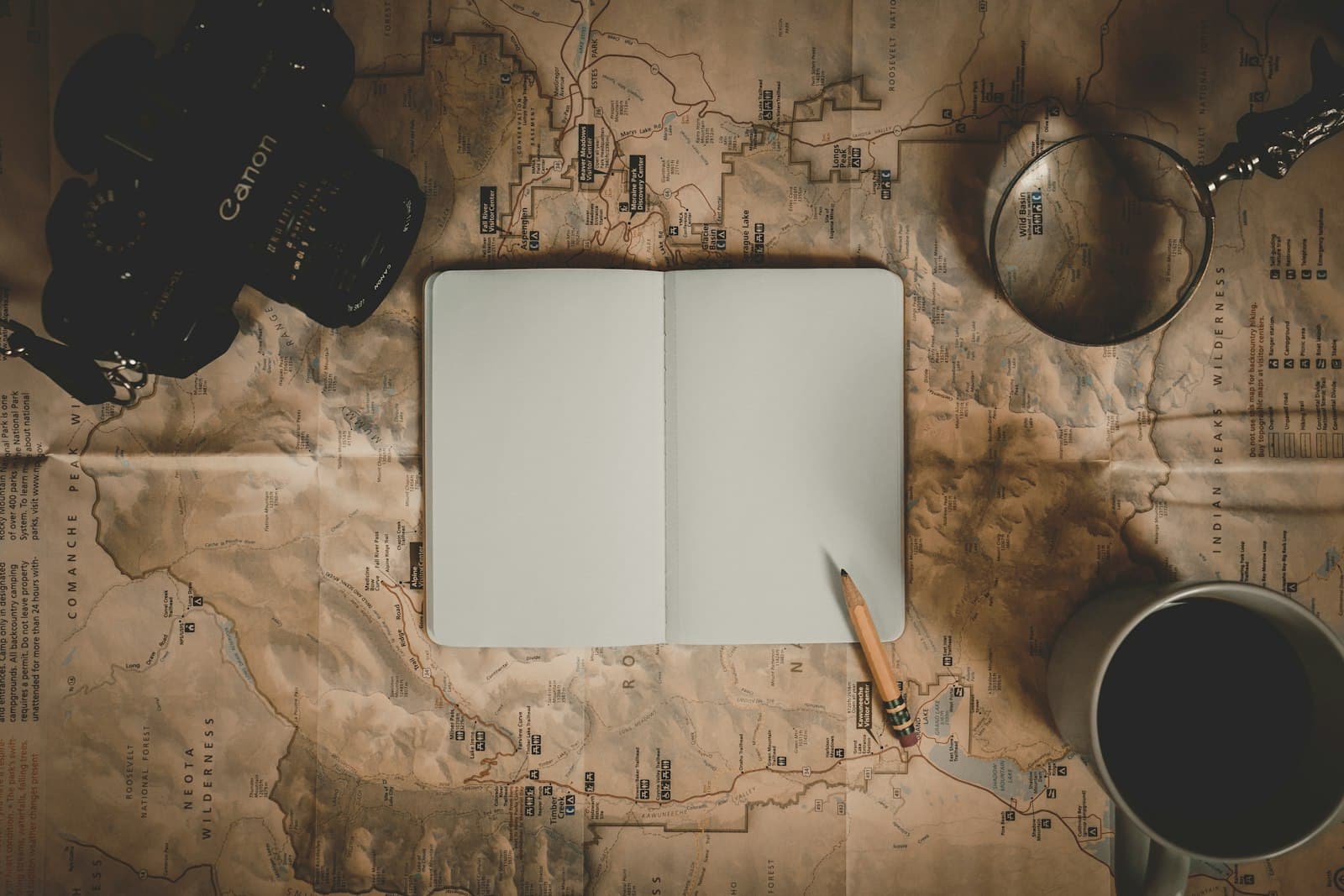 Un cuaderno abierto y una pluma sobre una mesa, bañados por la luz natural de la mañana.
